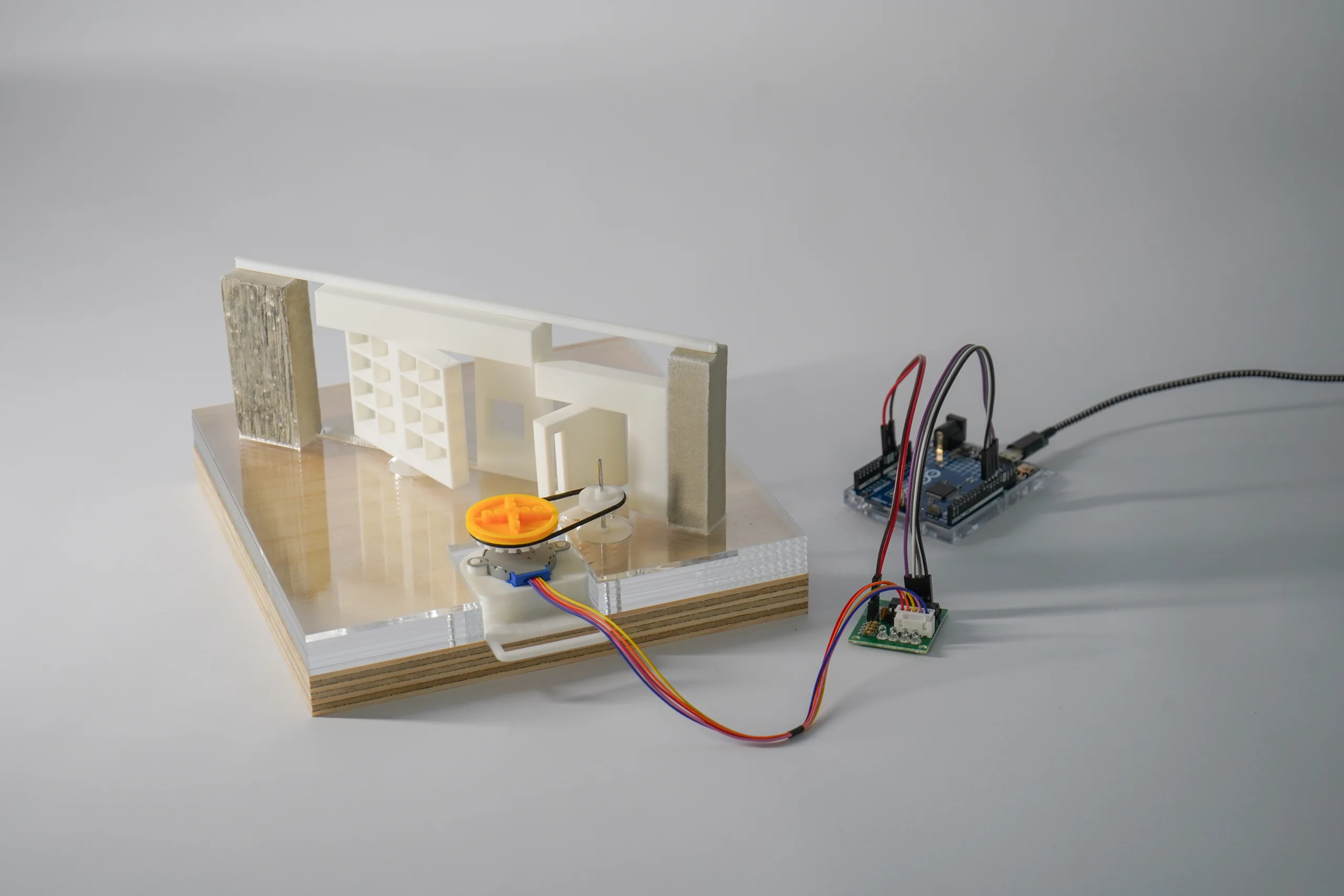 Tabletop partition prototype with a model mechanism, visible wiring, and electronic components
